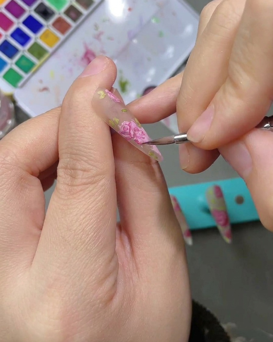 Aplicación de un top coat mate sobre un diseño finalizado de rosas en acuarela.