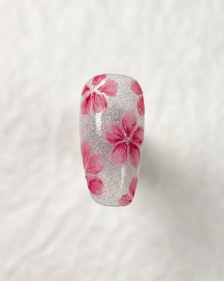 Primer plano de un diseño de flor de cerezo terminado, destacando los finos detalles oscuros en el centro de las flores.
