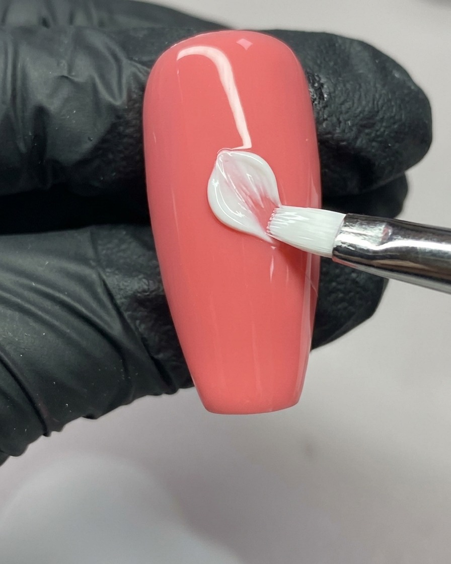 Un pincel de arte de uñas completando el lado derecho de un pétalo, mostrando la forma de V en la punta.