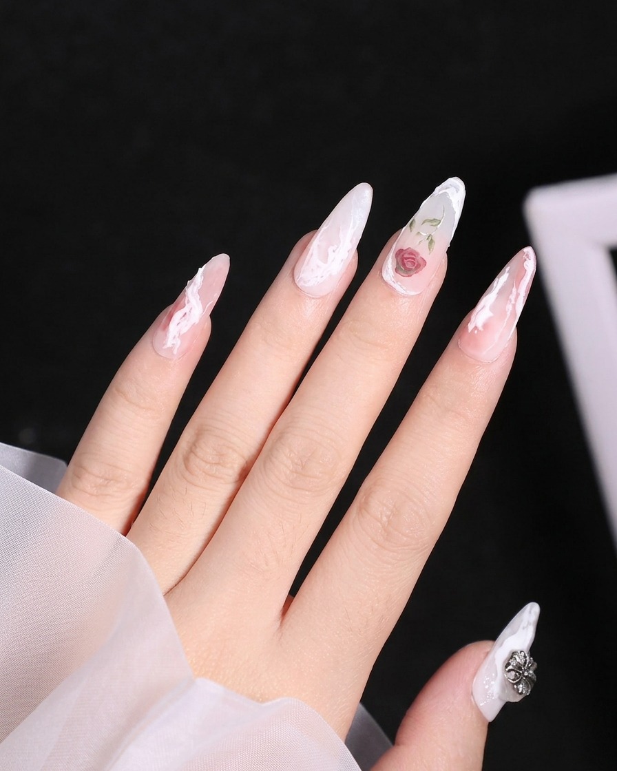 Primer plano de un pincel liner aplicando gel blanco para formar los contornos de los pétalos superiores de una rosa sobre una uña.