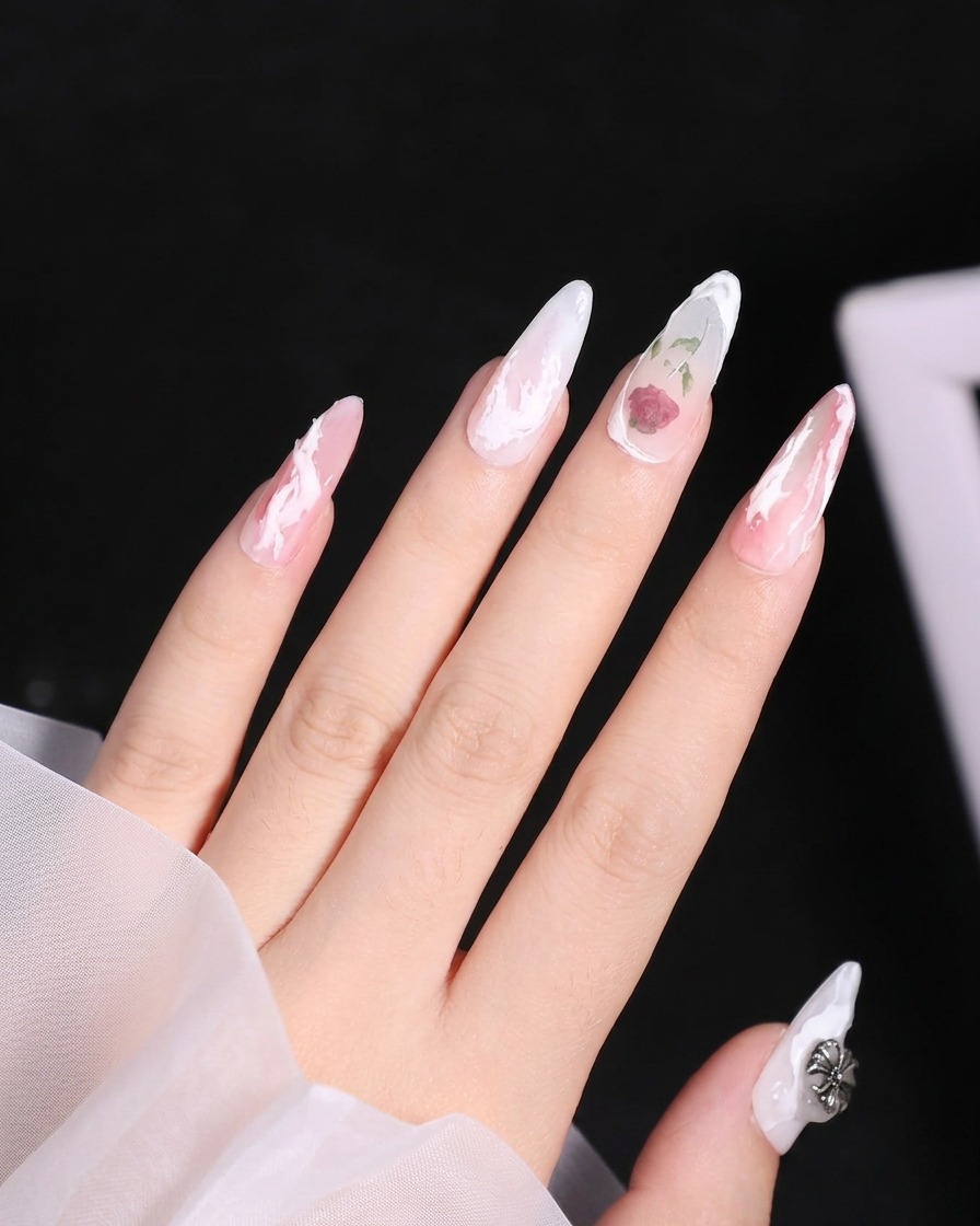 Primer plano de un pincel de uñas aplicando una línea blanca curva y elevada de gel 3D cerca de la cutícula del dedo anular.
