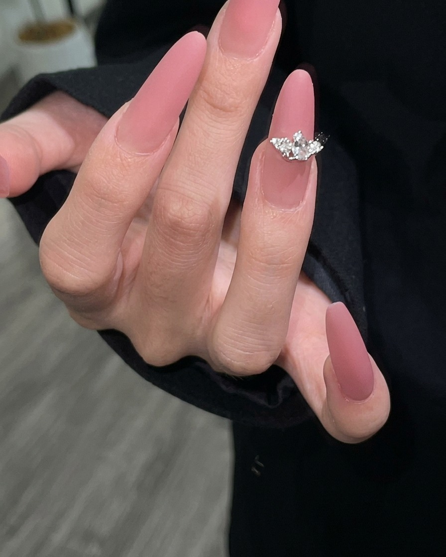 Segunda capa de esmalte de gel color malva aplicada para asegurar una cobertura completa.