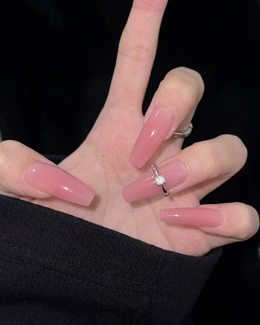 Primer plano de una lima de uñas dando forma almendrada al borde de una uña natural.