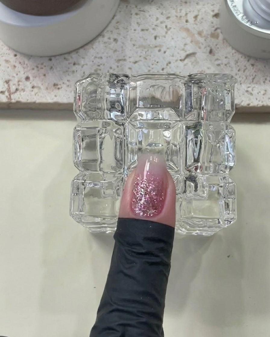 Un dedo con builder gel aplicado dentro de la lámpara UV/LED.