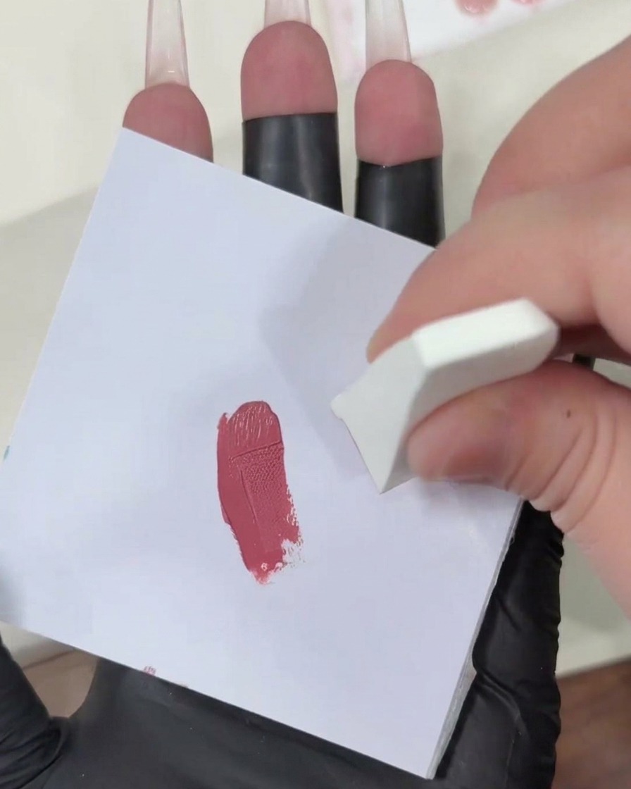 Dando toques con una esponja cargada de gel sobre una superficie blanca limpia para difuminar el color rosa.
