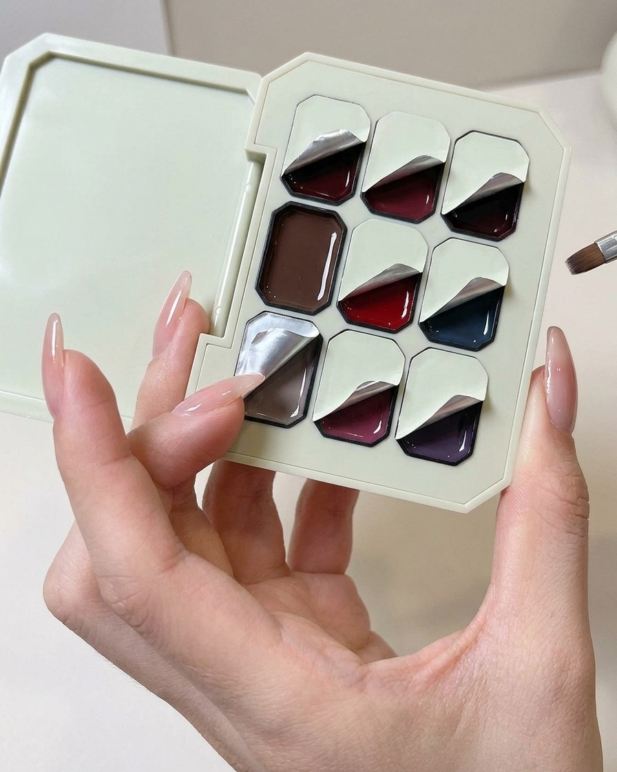 Una esponja de maquillaje en forma de cuña siendo presionada sobre una paleta de gel sólido morado claro.
