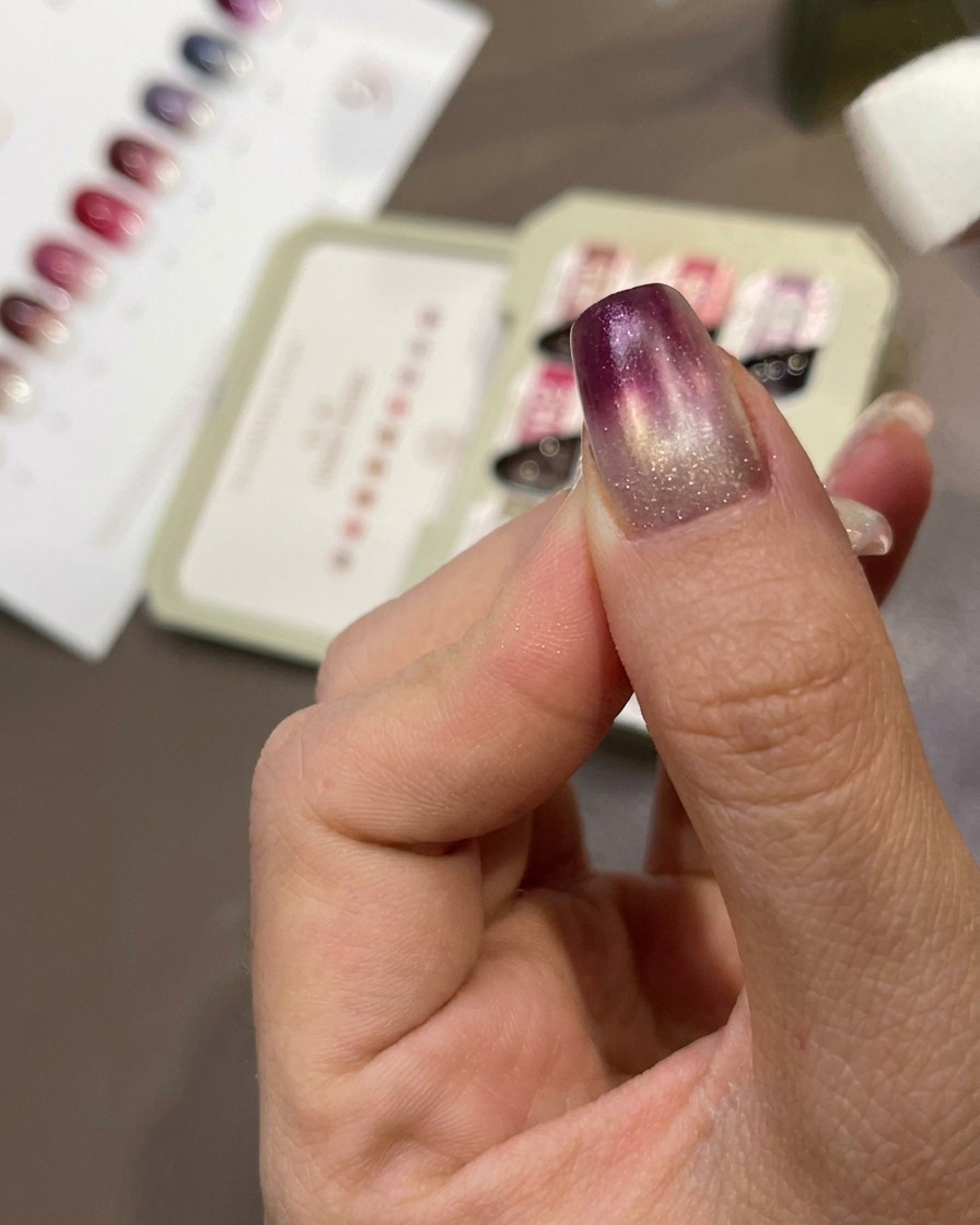 Una esponja dando toques de gel morado sobre la uña para crear un efecto degradado.