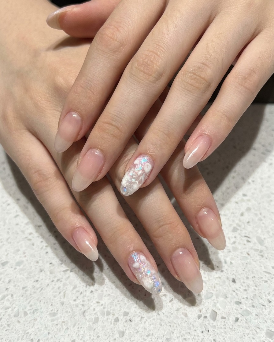 Primer plano de una esponja aplicando gel blanco sobre una uña rosa nude para crear un degradado ombré.