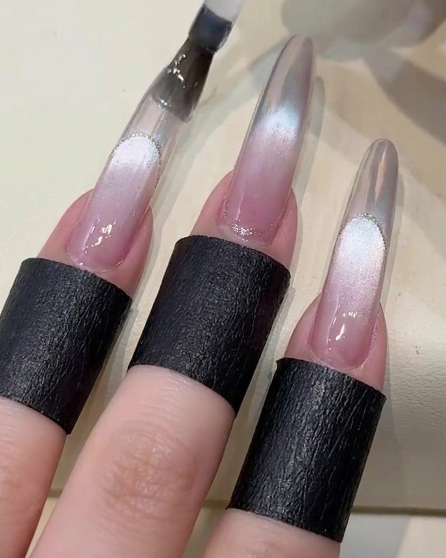 Un pincel de gel aplicando un top coat transparente sobre el diseño de la uña en preparación para curar bajo una lámpara UV.