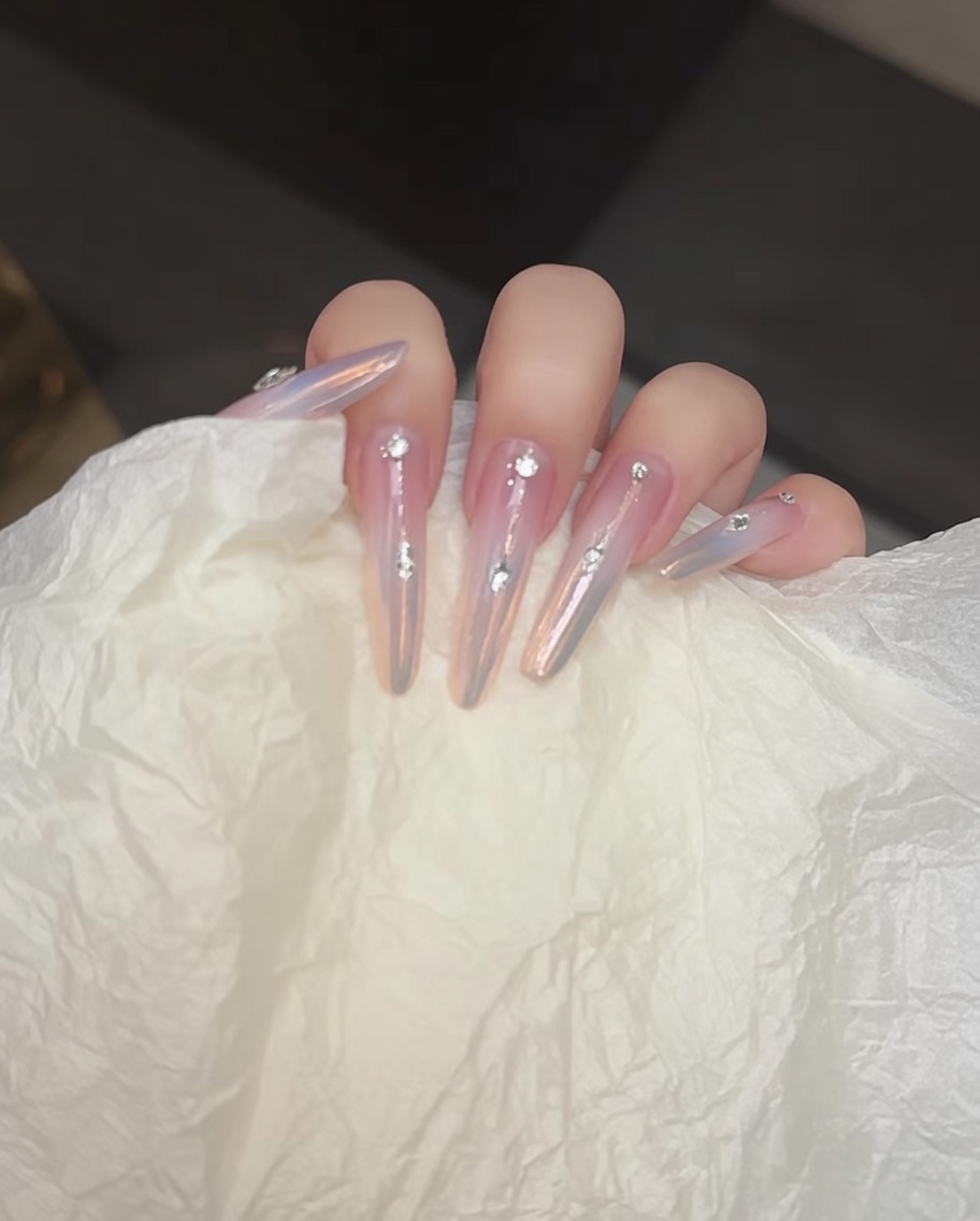Un pincel aplicando un top coat transparente sin capa pegajosa sobre la superficie de la uña.