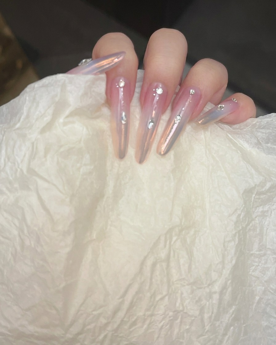 Uñas siendo puestas bajo una lámpara UV/LED para curar el top coat de refuerzo.