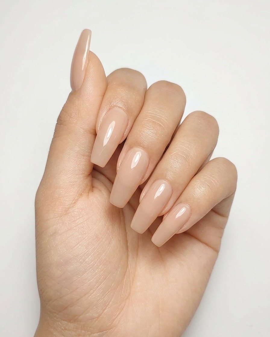 Primer plano de una uña de gel nude con un diseño completo de estrella plateada metálica curándose bajo una lámpara.