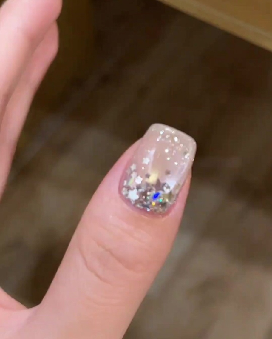 Primer plano de una uña con efecto cat-eye curándose dentro de una lámpara UV/LED.