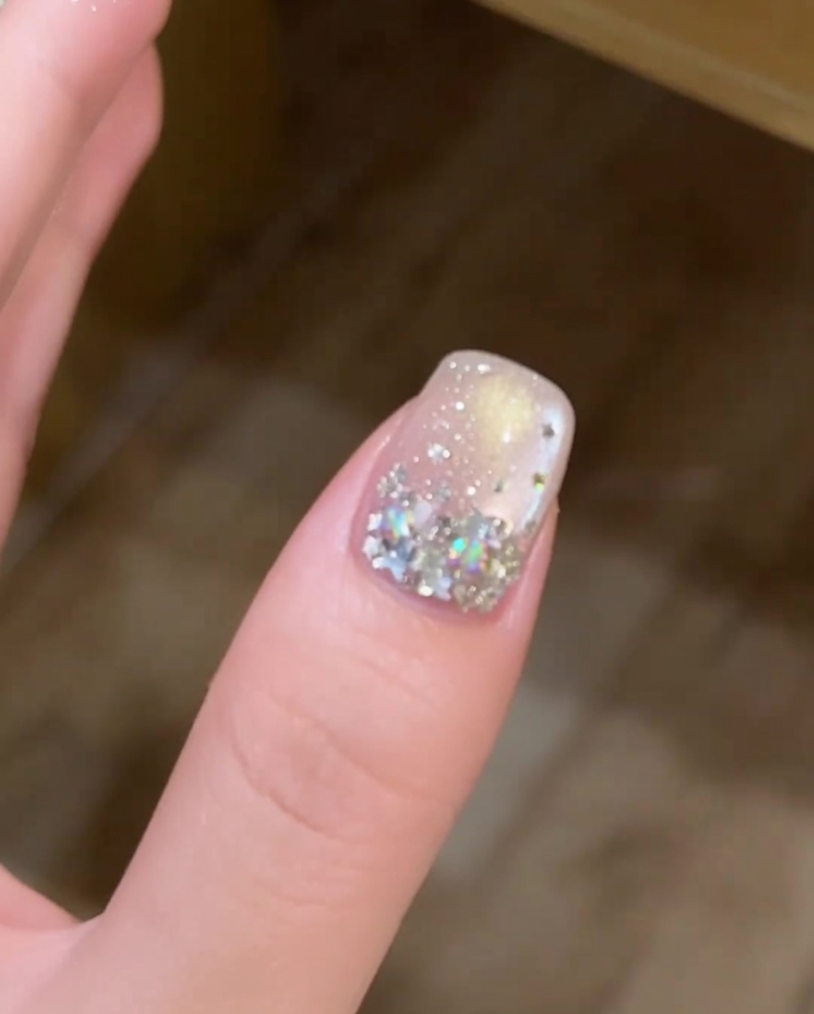 Una mano posicionada dentro de una lámpara de uñas profesional, con la uña decorada claramente visible bajo la luz UV.