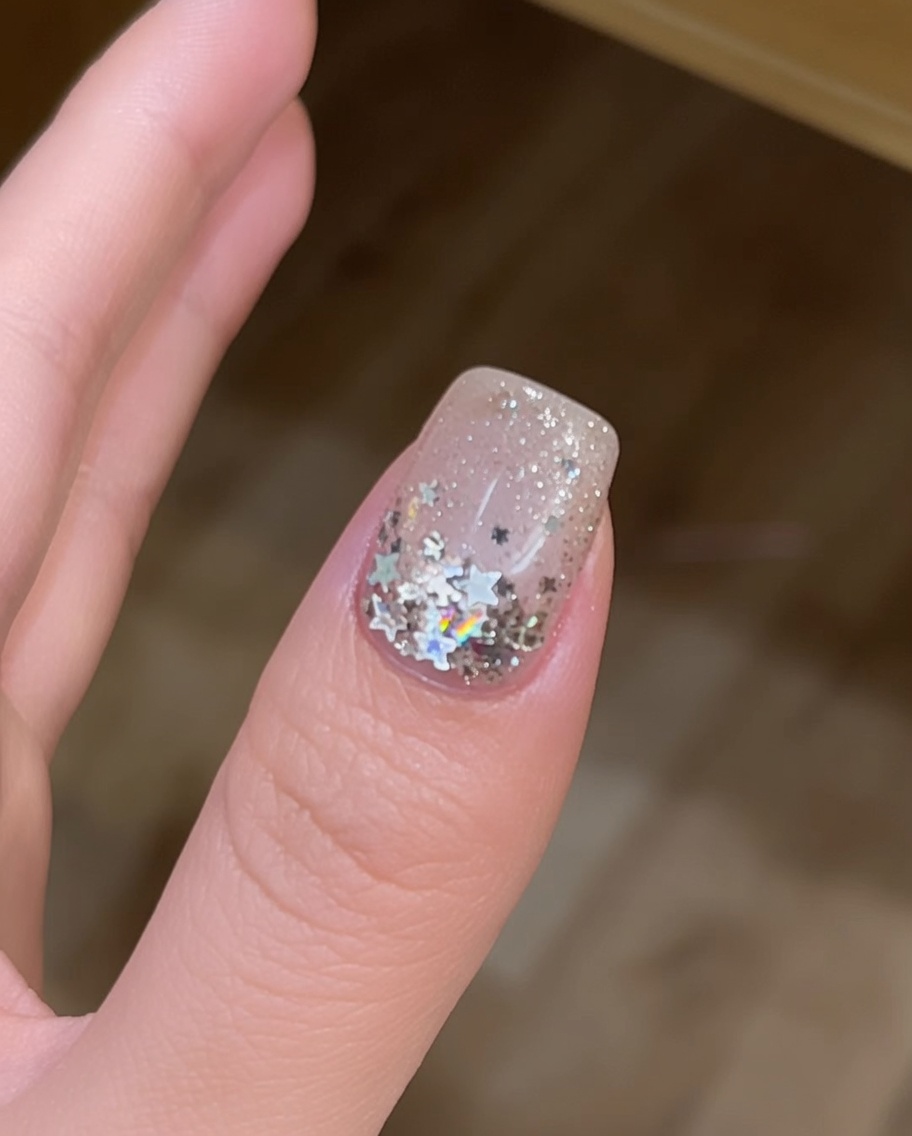 Vista de cerca de uñas curándose bajo una lámpara UV, significando la finalización de la aplicación.