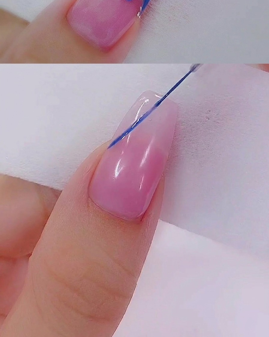 Dos pequeños puntos azules colocados uno al lado del otro sobre la superficie de la uña, creados con un punzón o dotting tool.