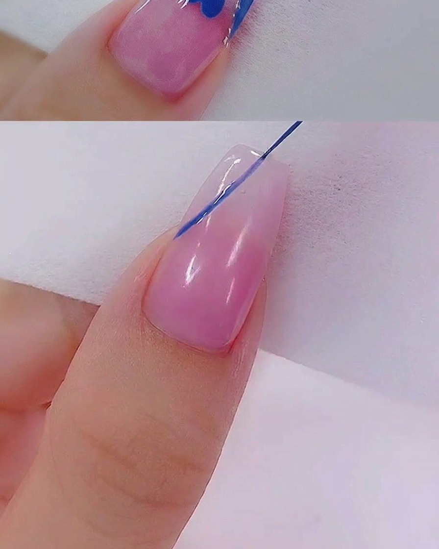 Un pincel delineador arrastrando cuidadosamente el gel azul para formar un corazón en la superficie de la uña.