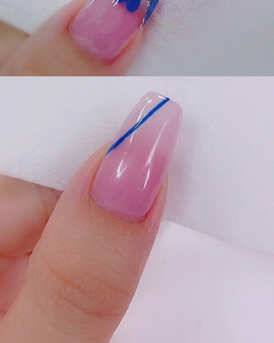Primer plano de un corazón azul siendo rellenado con gel utilizando un pincel delineador fino para nail art.