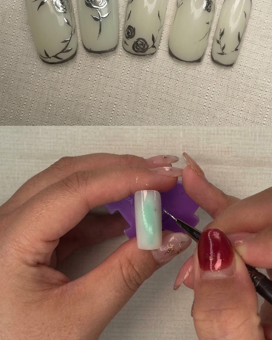 Una uña con una segunda capa de esmalte blanco lechoso siendo curada bajo una lámpara de uñas.