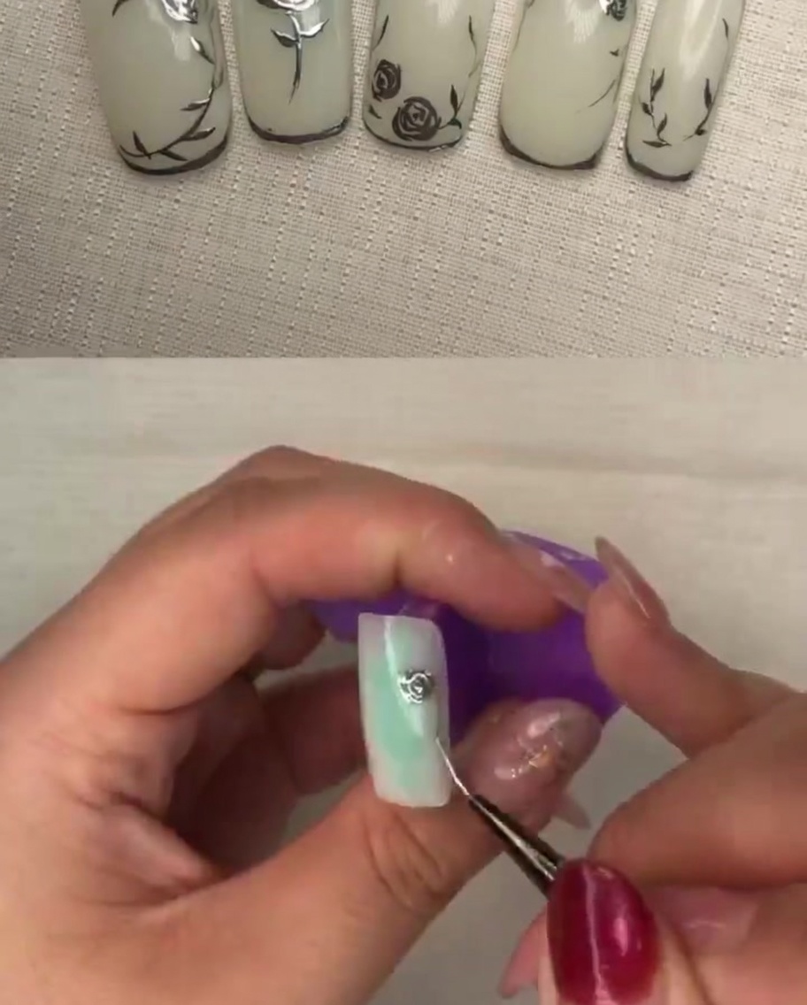 Un primer plano de un pincel aplicando presión a los pétalos de gel metálico para crear textura y profundidad.