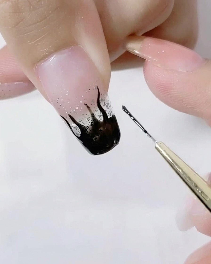 Primer plano de un pincel liner detallando las puntas afiladas de las llamas negras.