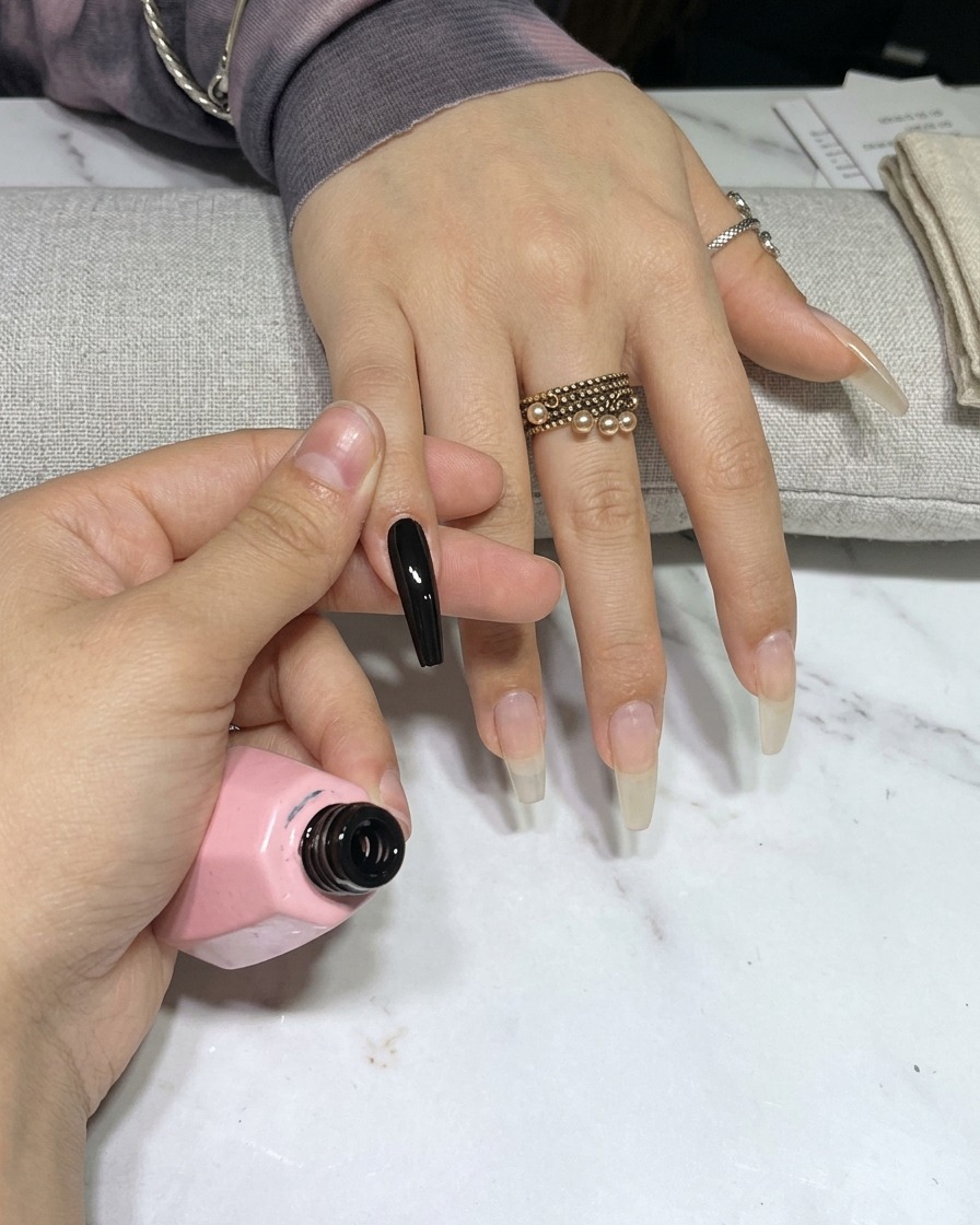 Una mano dentro de una lámpara de uñas UV, con las uñas bajo la luz.