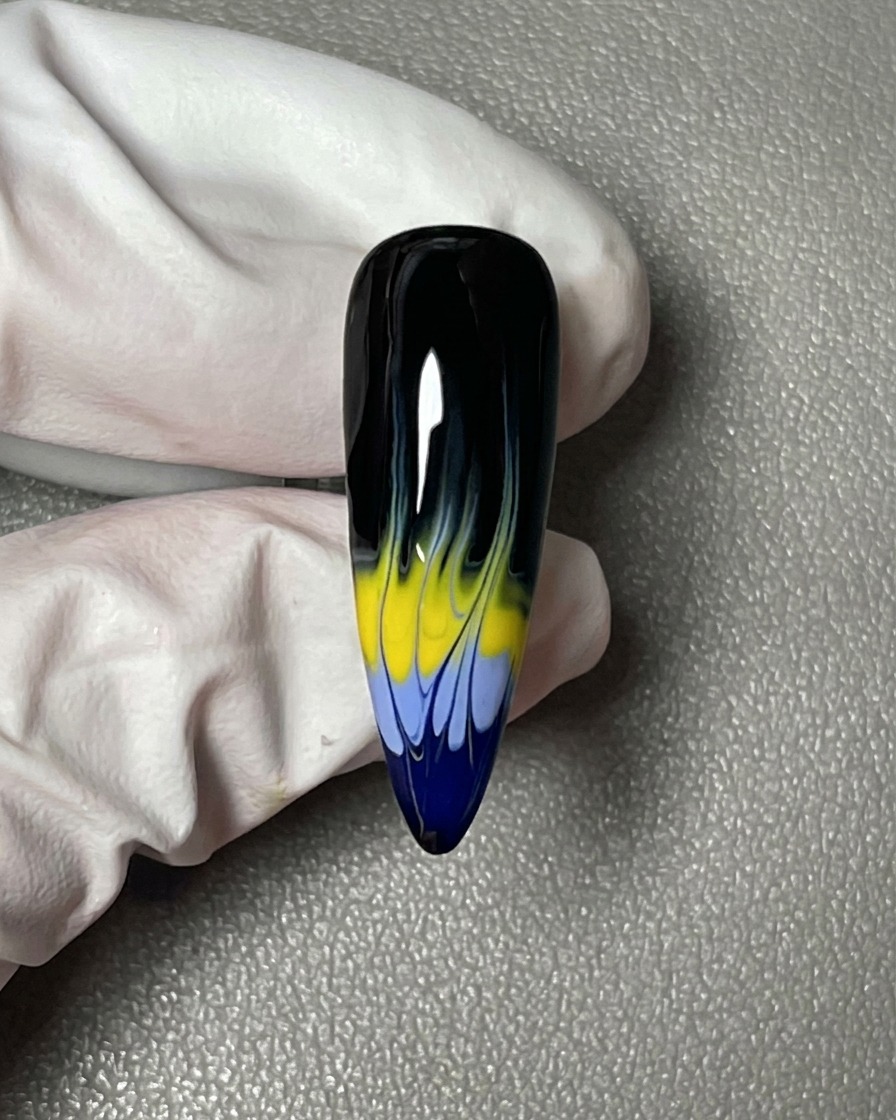 Primer plano de una uña cubierta por completo con un esmalte en gel negro, liso y opaco.