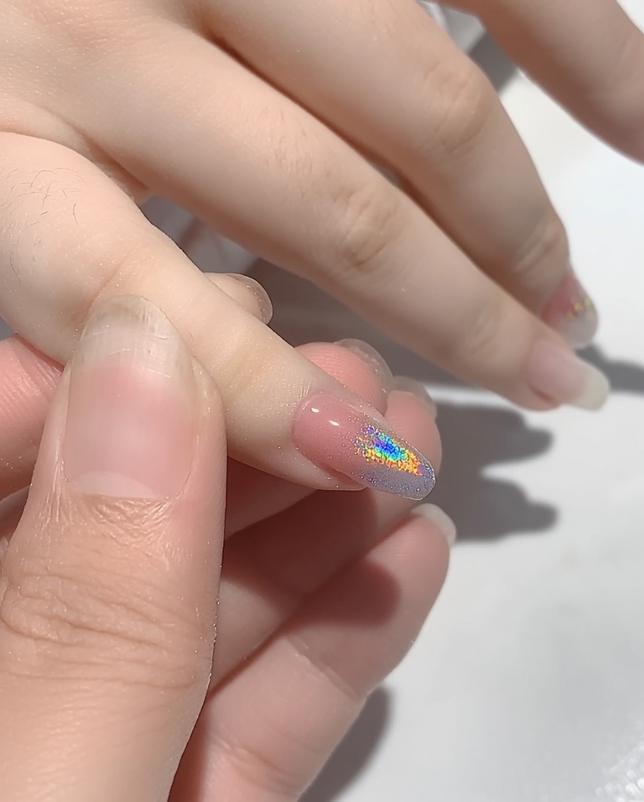 Mano colocada dentro de una lámpara de uñas UV para curar el polvo recién aplicado.