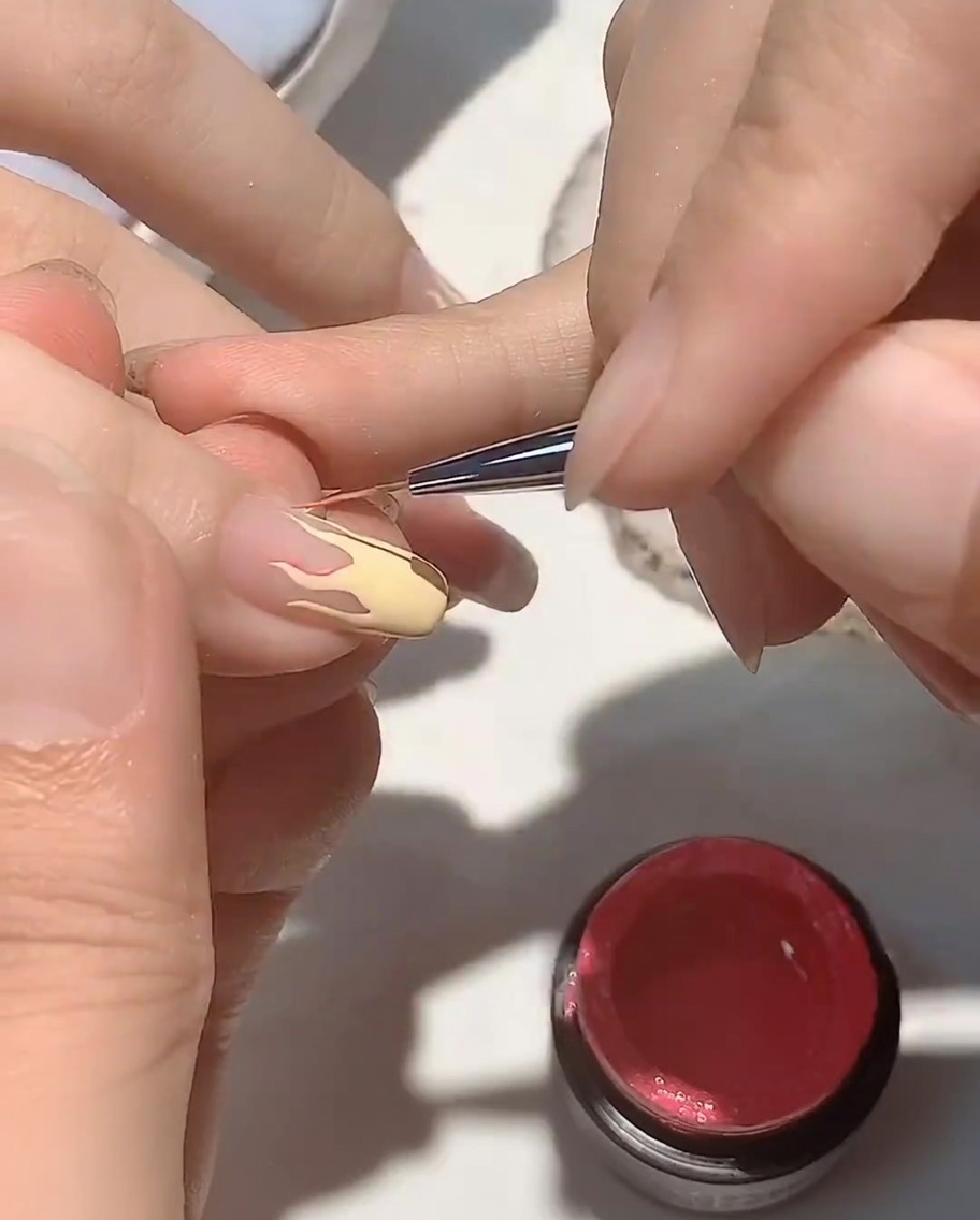 Primer plano de una mano descansando dentro de una lámpara UV para uñas, con el enfoque en las uñas que se están curando.