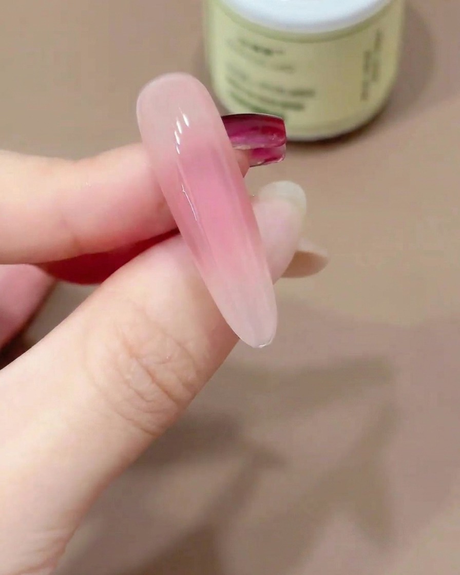 Una uña sostenida boca abajo para permitir que el top coat en gel se autonivele.