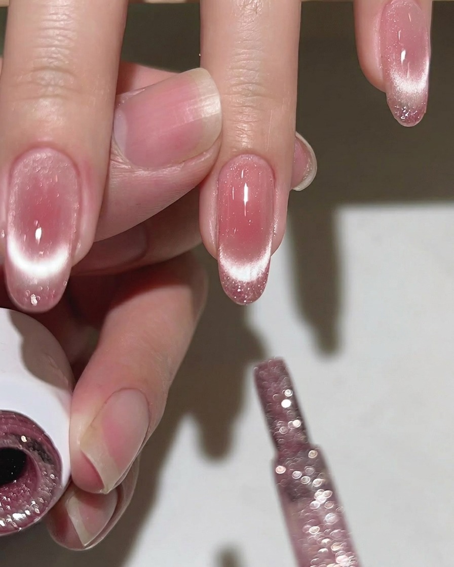 Un pincel aplicando una capa de top coat transparente y brillante a una uña.