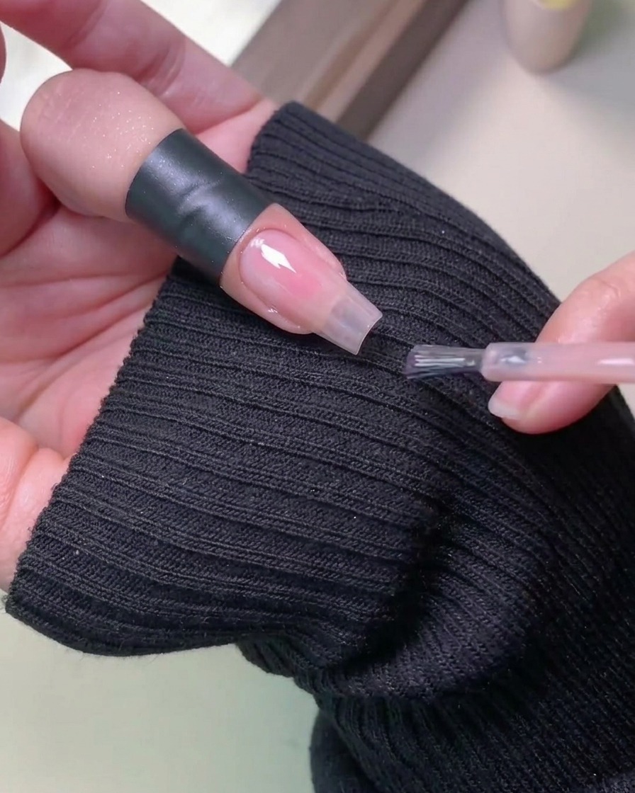 Una mano dentro de una lámpara profesional UV para curar el esmalte en gel.