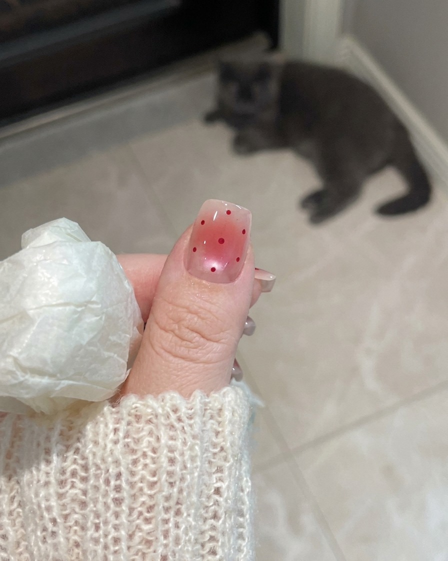 Primer plano de una mano con uñas de acabado mate reposando bajo la luz UV de una lámpara de uñas.