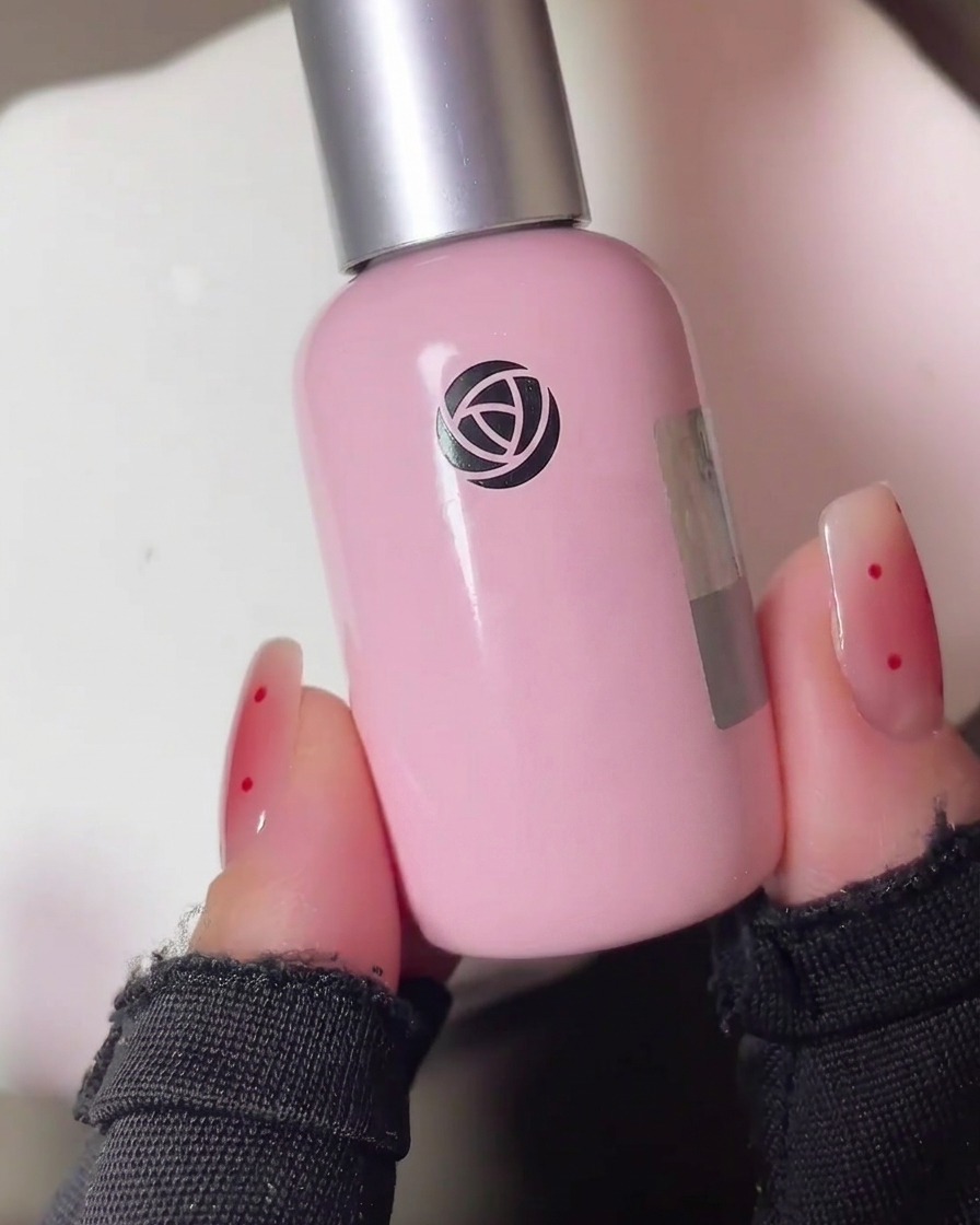 Una mano con las uñas pintadas con gel colocada dentro de una lámpara UV profesional para su curado.