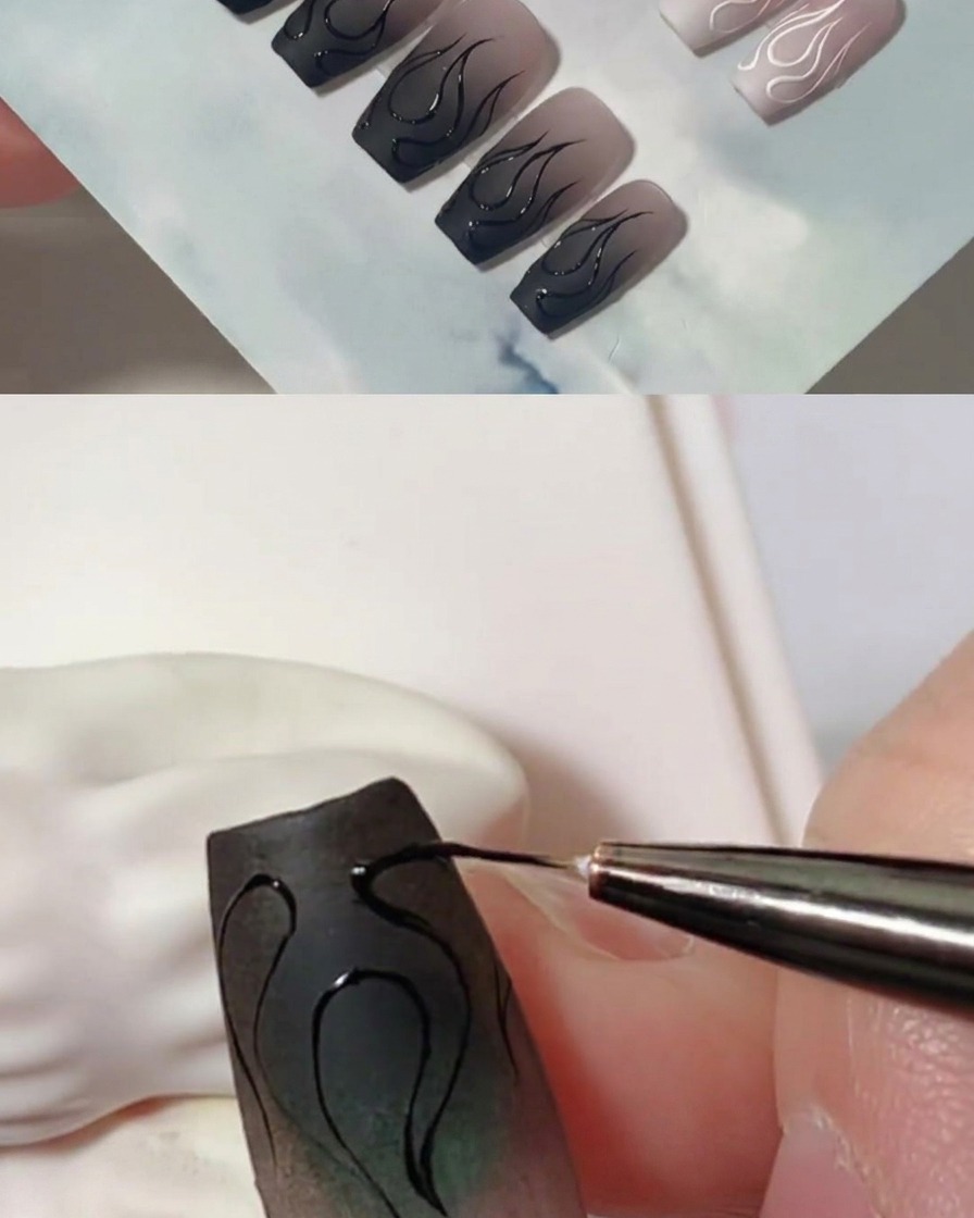 Un primer plano que muestra un pincel delineador añadiendo capas de gel negro para espesar los contornos de llama en una uña mate.