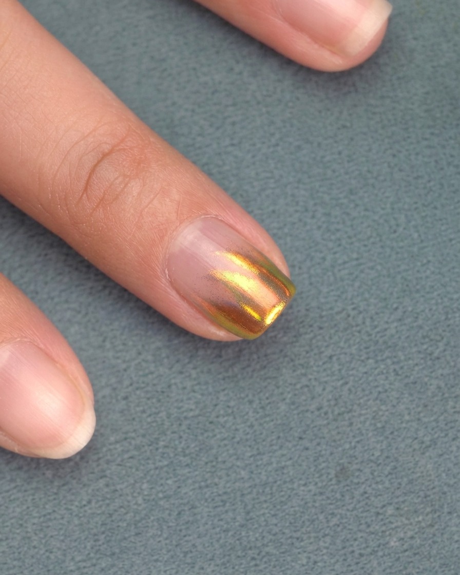 Una mano posicionada dentro de una lámpara de uñas UV/LED, con las uñas curándose.