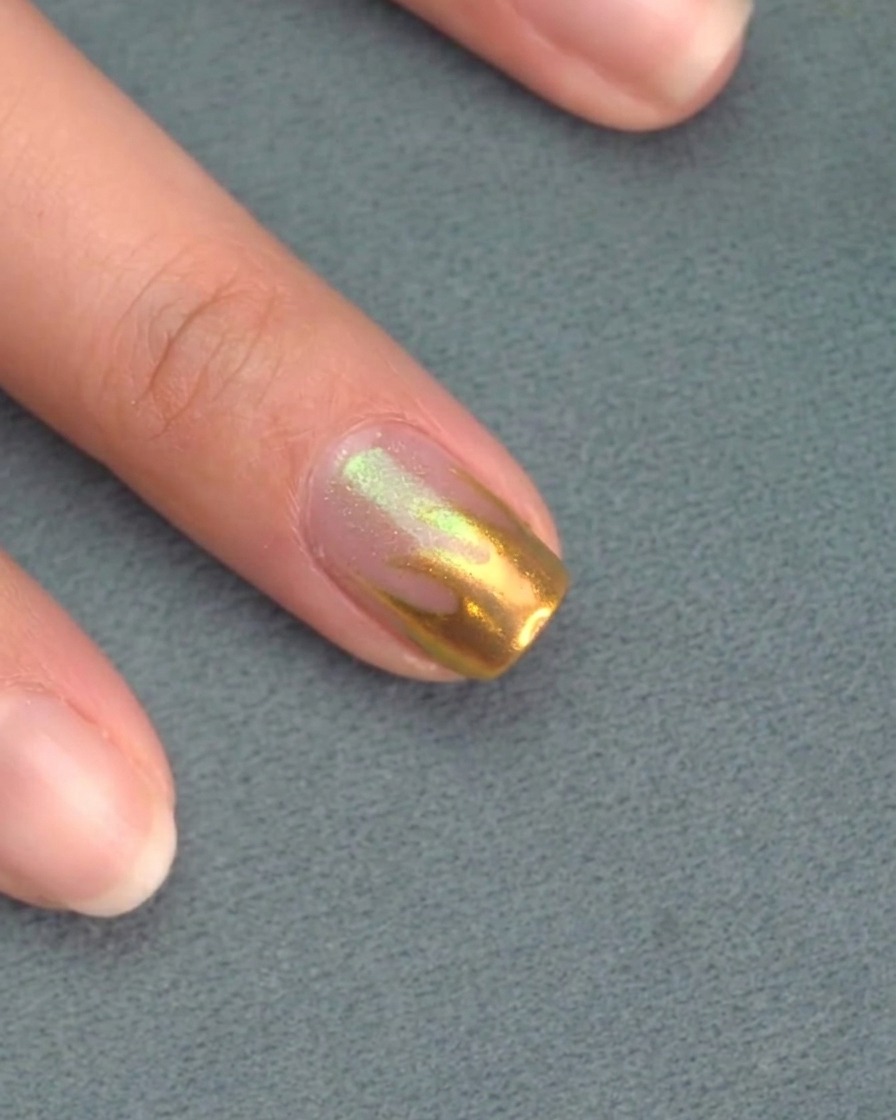 Aplicando un top coat mate transparente sobre las uñas pintadas de rosa.