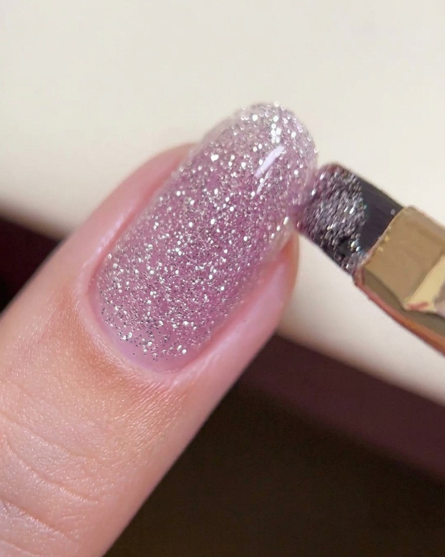 Un pincel deslizando una gota espesa de gel efecto diamante para crear una capa estructurada.