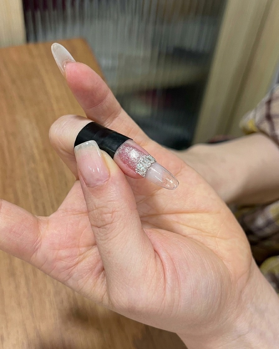 Una mano posicionada dentro de una lámpara de uñas profesional, con el enfoque en la uña recibiendo el curado final.