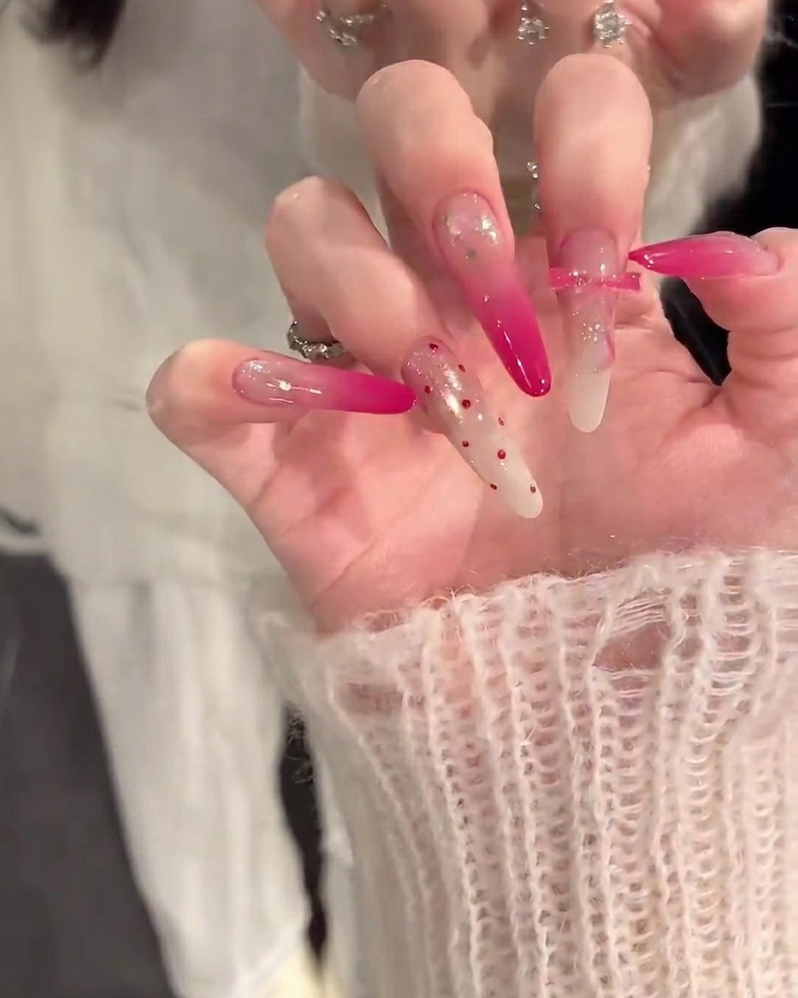 Primer plano de una mano con un pincel aplicando una capa base color nude sobre uñas limpias y preparadas.