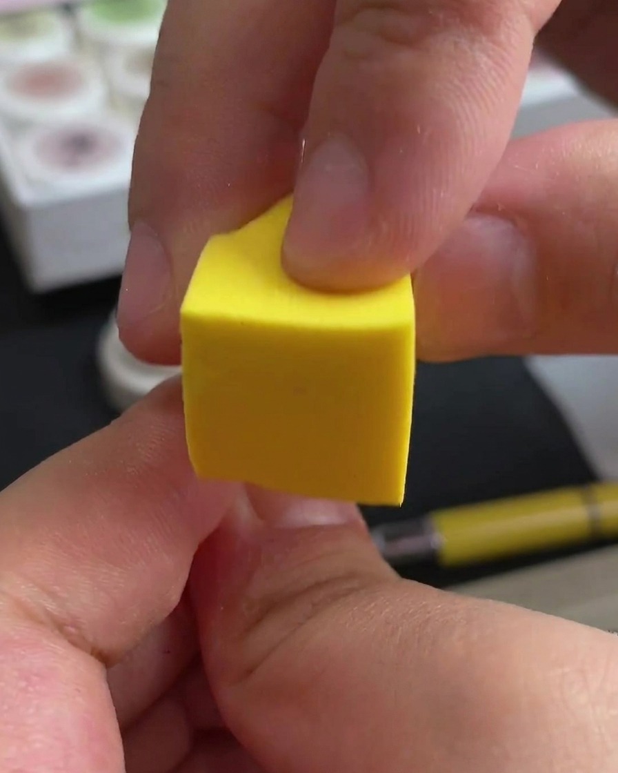 Una mano colocando las uñas bajo una lámpara profesional de uñas UV/LED para curar.