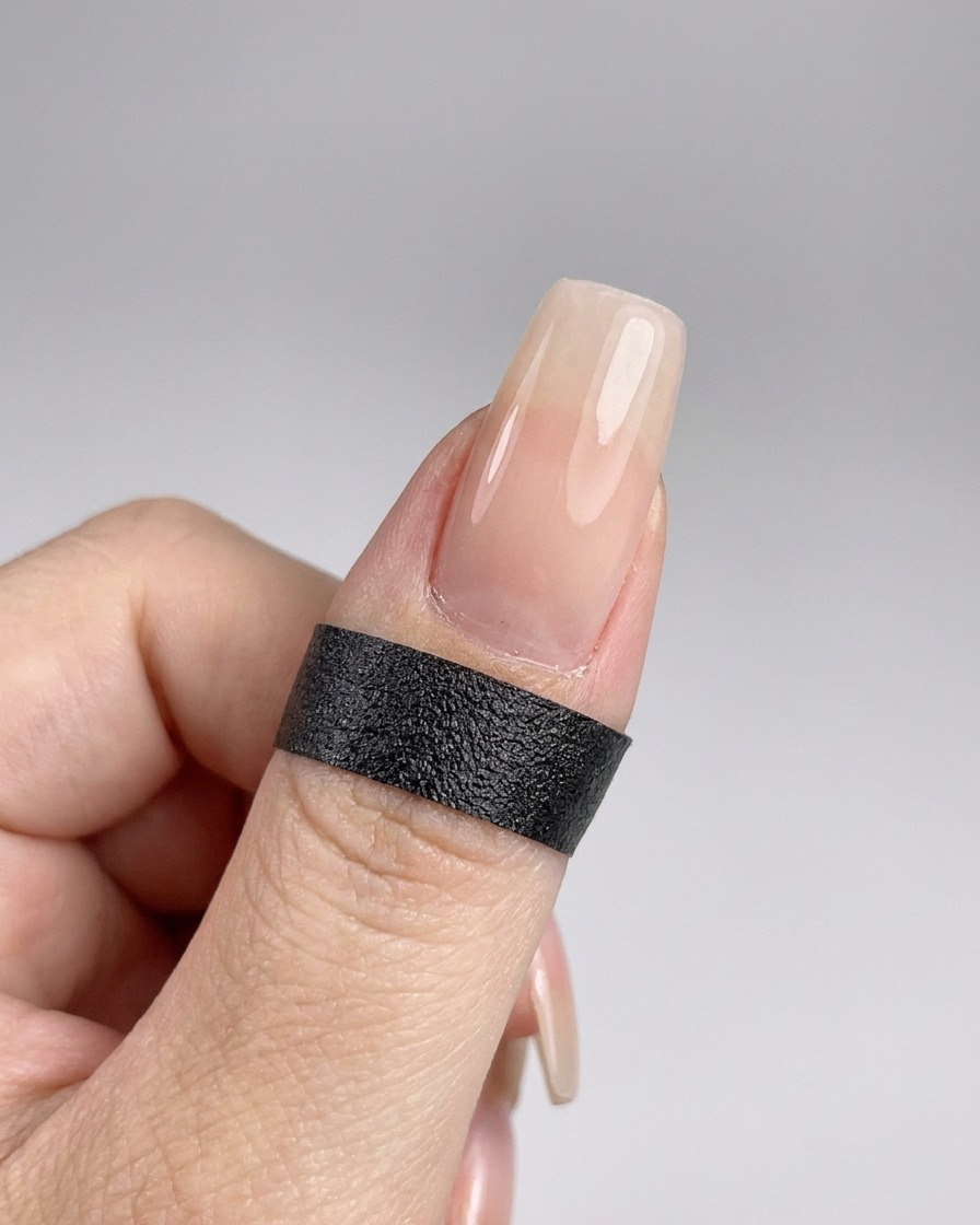 Una mano posicionada dentro de una lámpara UV para curar el top coat recién aplicado.