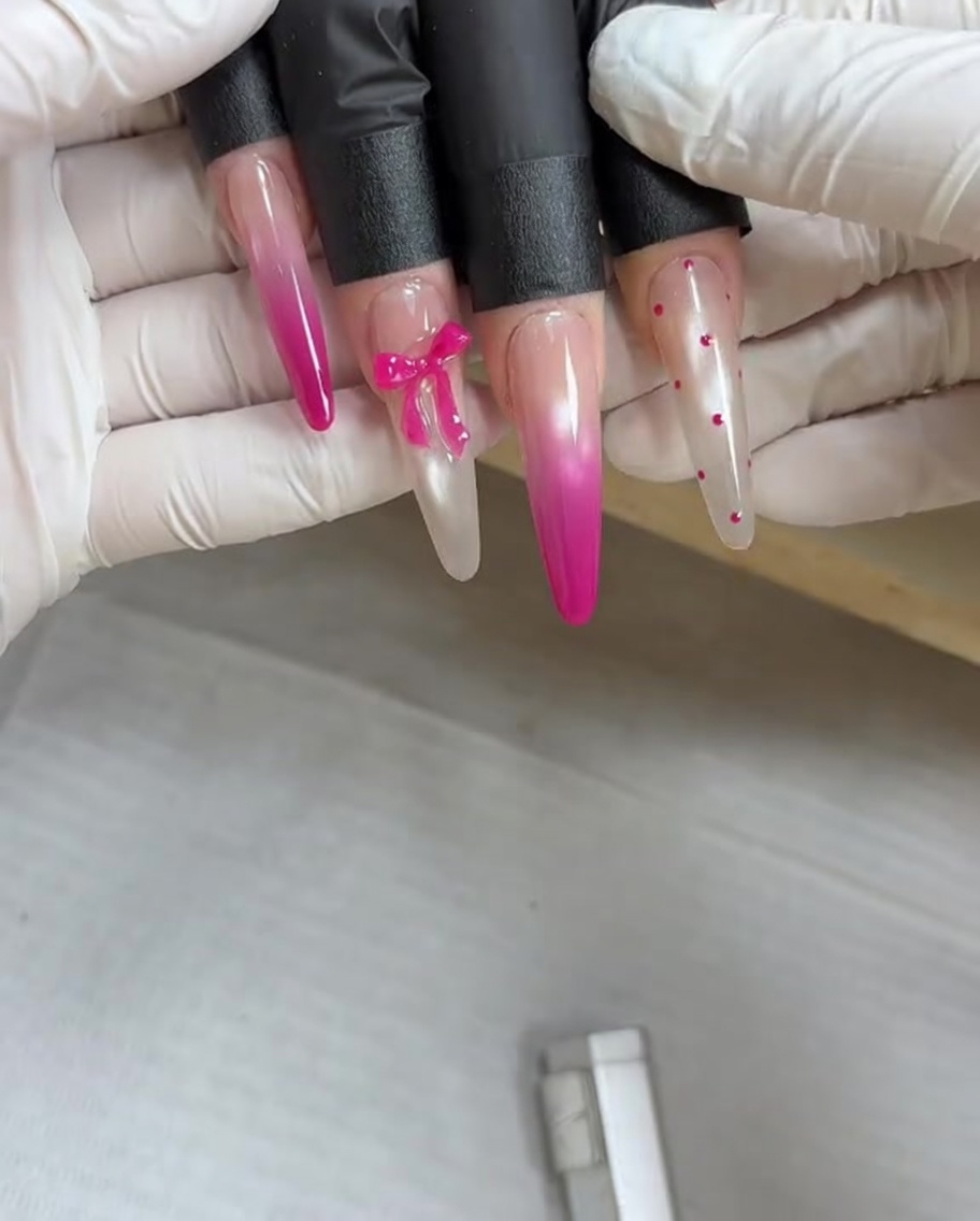 Una herramienta magnética sostenida sobre una uña cubierta de gel metálico húmedo para atraer los pigmentos magnéticos a un diseño.