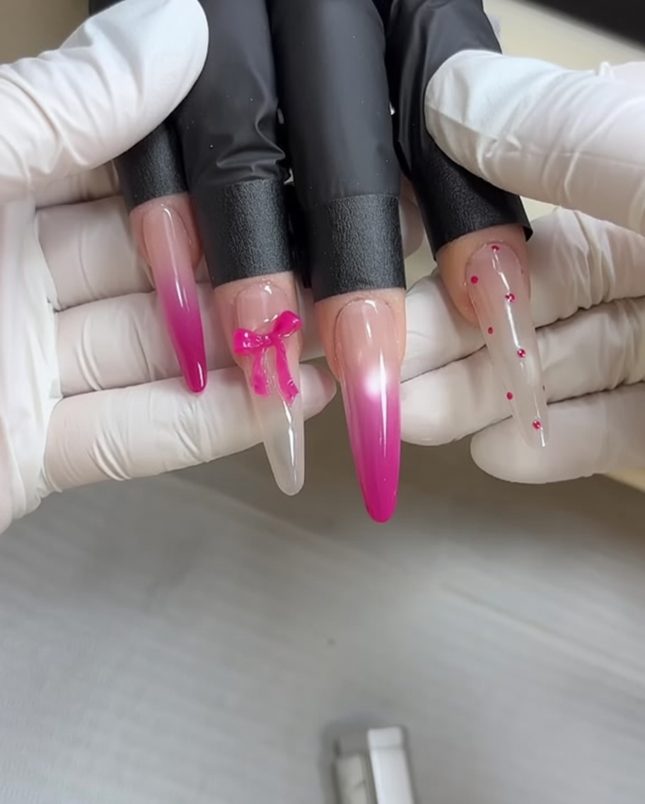 Una esponja de maquillaje aplicando esmalte de gel rosa a una uña para crear un efecto de degradado ombré suave.
