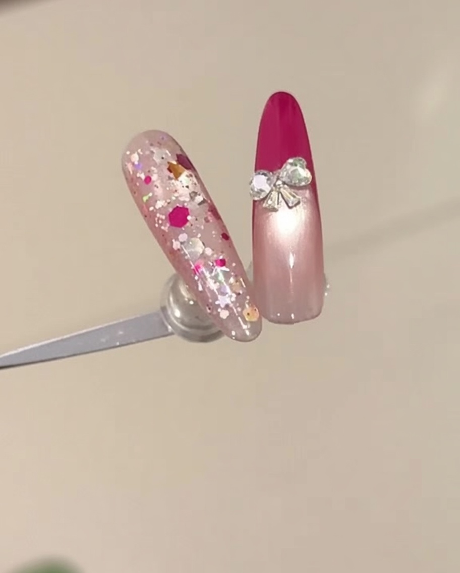 Un primer plano de una mano con una manicura francesa en rojo rosa siendo colocada dentro de una lámpara de uñas UV.