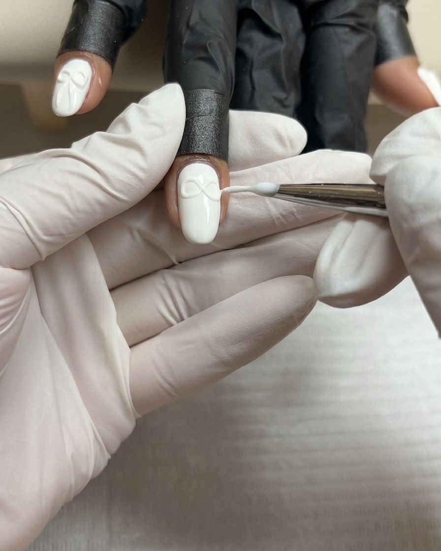 Un pincel fino dando forma a la segunda ala de un lazo de gel 3D para que coincida con la primera.