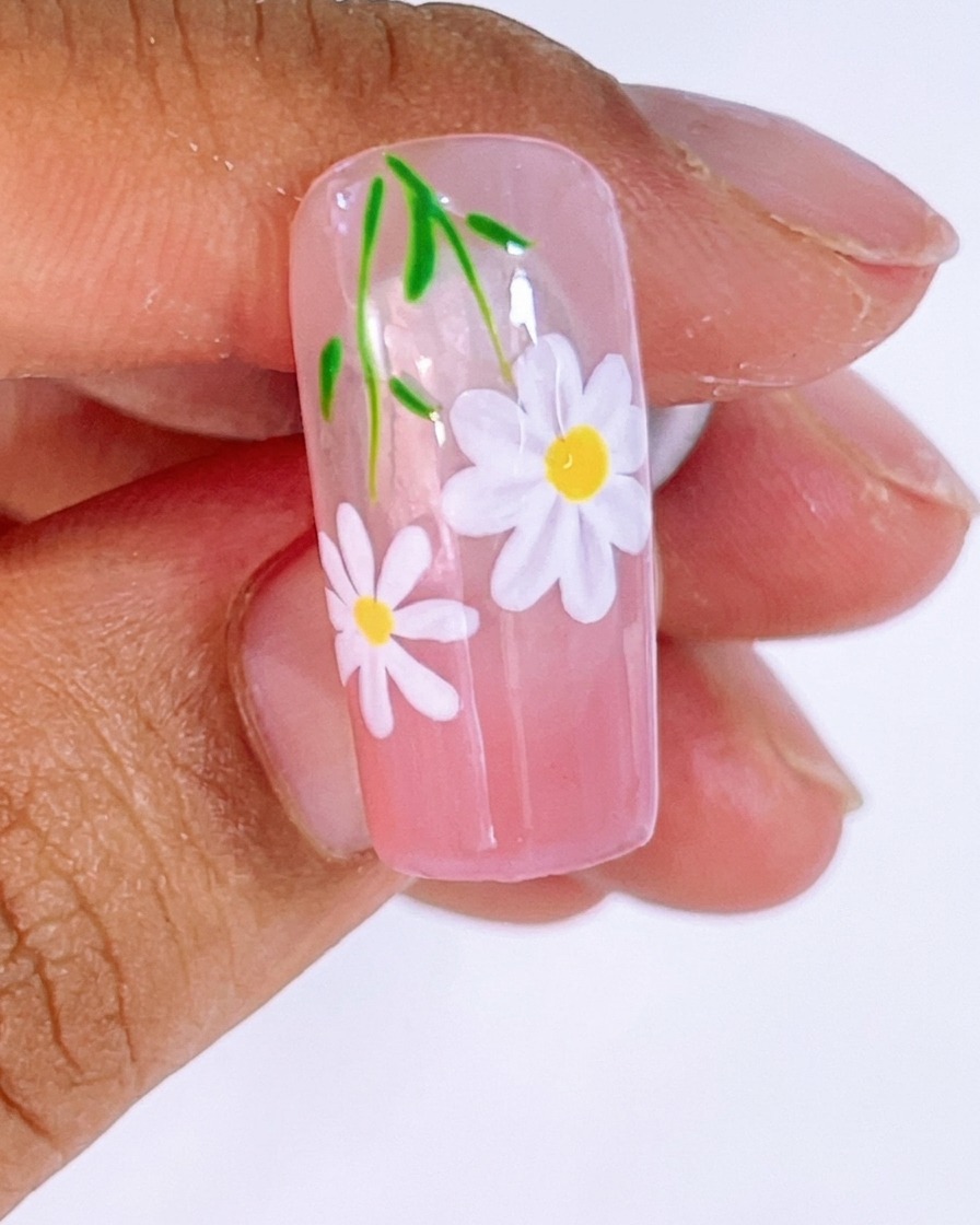 Gel blanco siendo aplicado con un pincel liner para formar los pétalos de la margarita sobre las líneas guía.