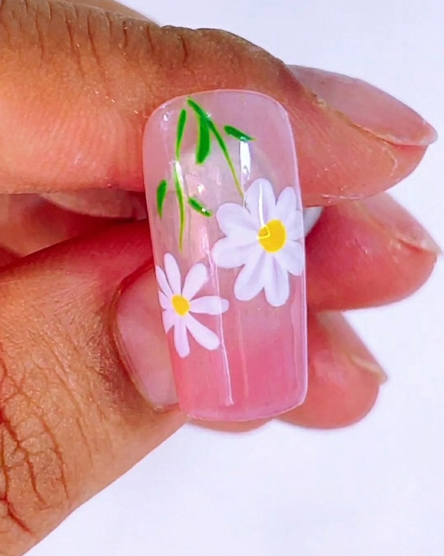 El diseño de uñas terminado bajo la luz UV durante el proceso de curado final de 120 segundos.