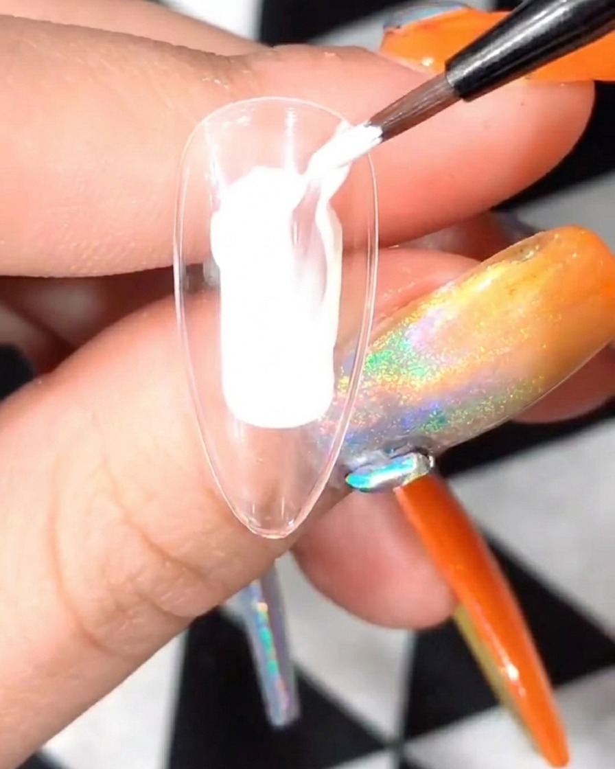 Una uña con pétalos blancos siendo curada dentro de una lámpara UV/LED.