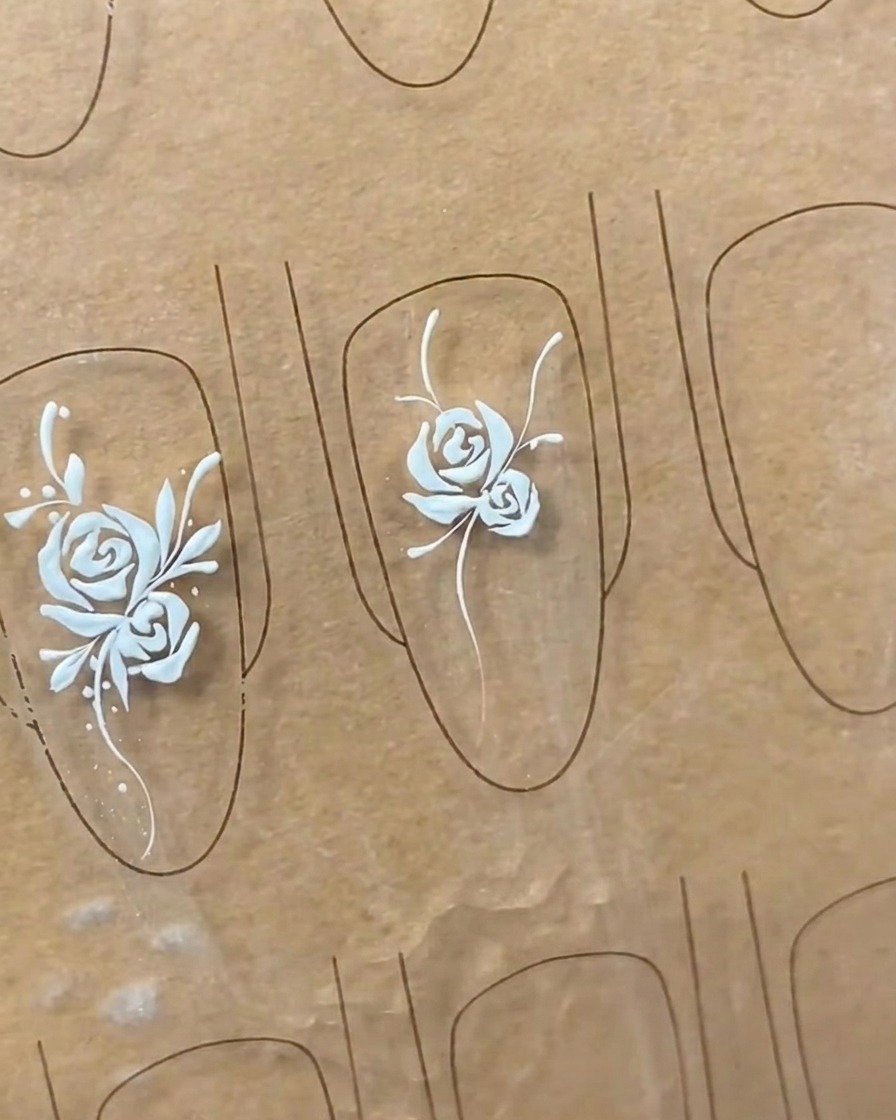 Primer plano que muestra el refinamiento de las formas de las hojas en un diseño de nail art, añadiendo detalle y plenitud a las hojas.